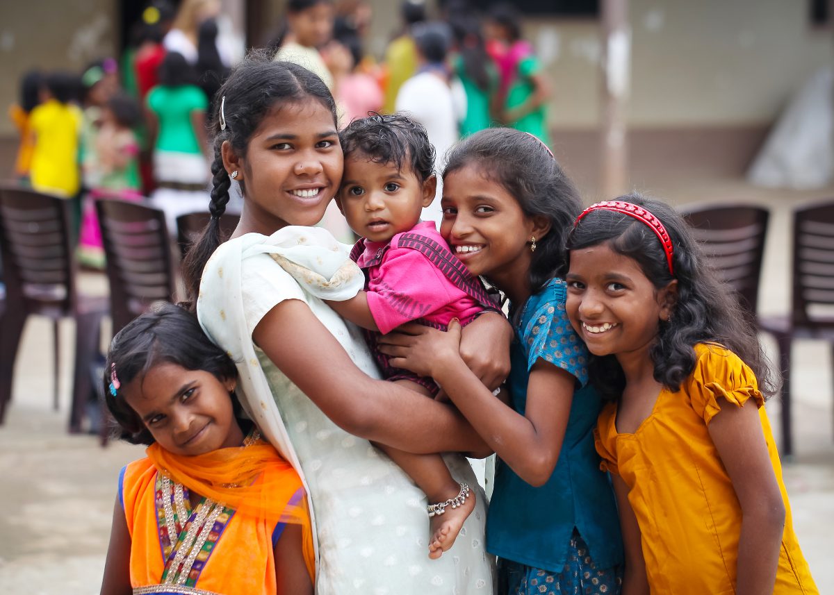 A group of smiling girls in bright cloths from the Children of Faith Home in India