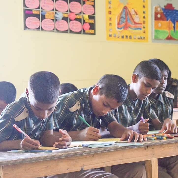 a group of male students at a desk in the classroom