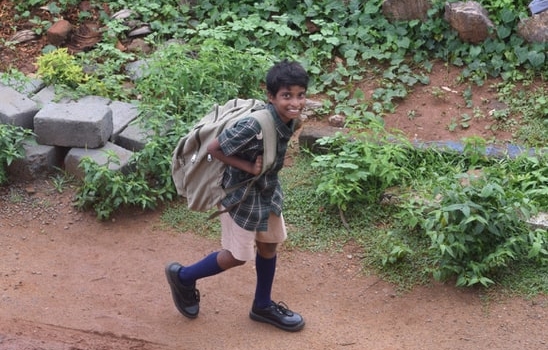 boy walking home with his backpack