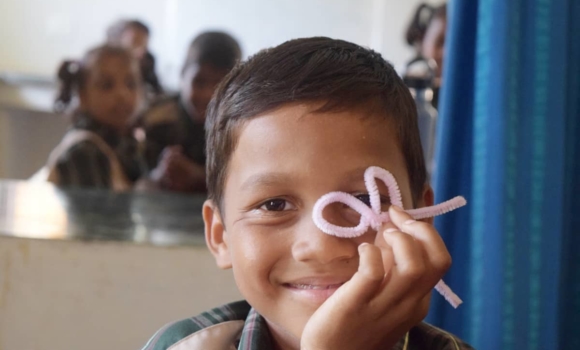 boy with pipecleaner project in classroom