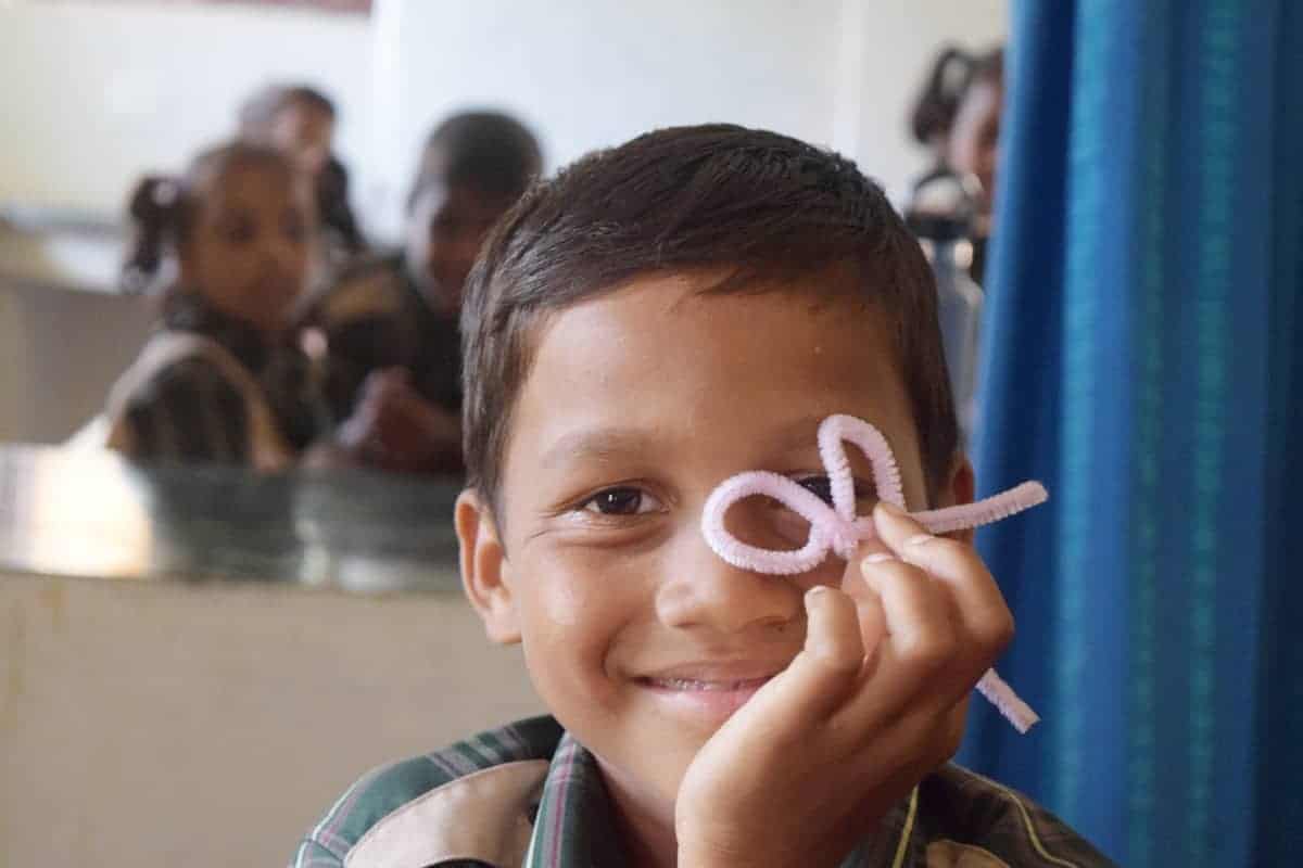 boy with pipecleaner project in classroom