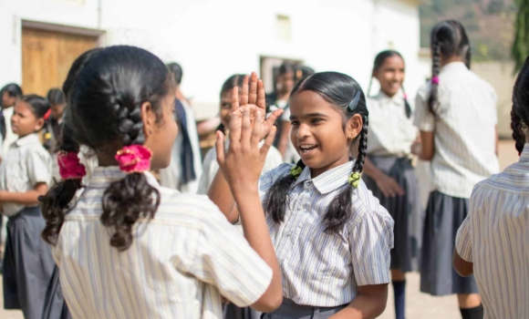 girls playing patty cake in school uniforms