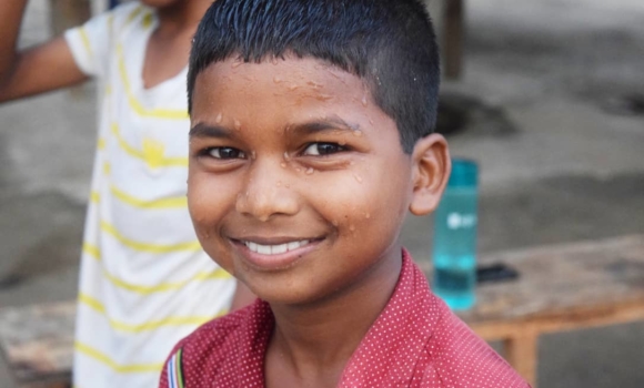 young boy face covered in water