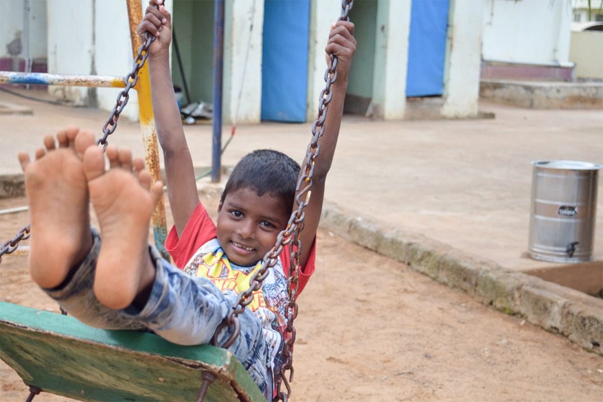 young boy playing on the swingset