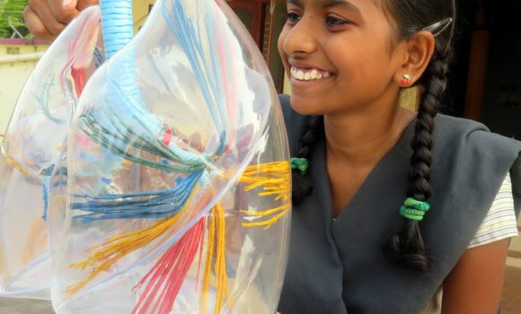 A Student at the Children of Faith Home School looking at a model of lungs