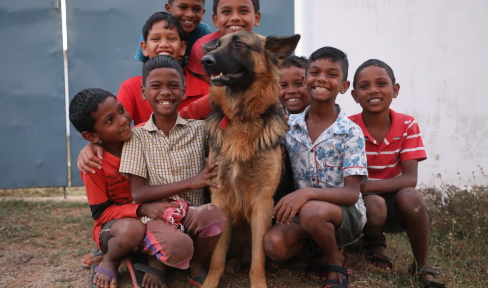 Boys surround their pet dog