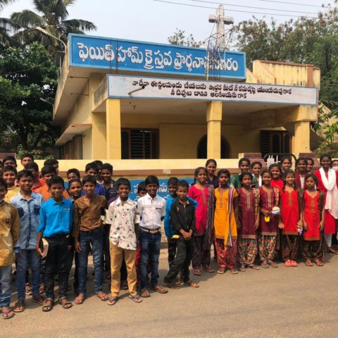 Children are dreesed for Easter and gather in front of their church