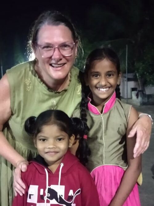 A sponsor with two young girls at the Children's Home in India