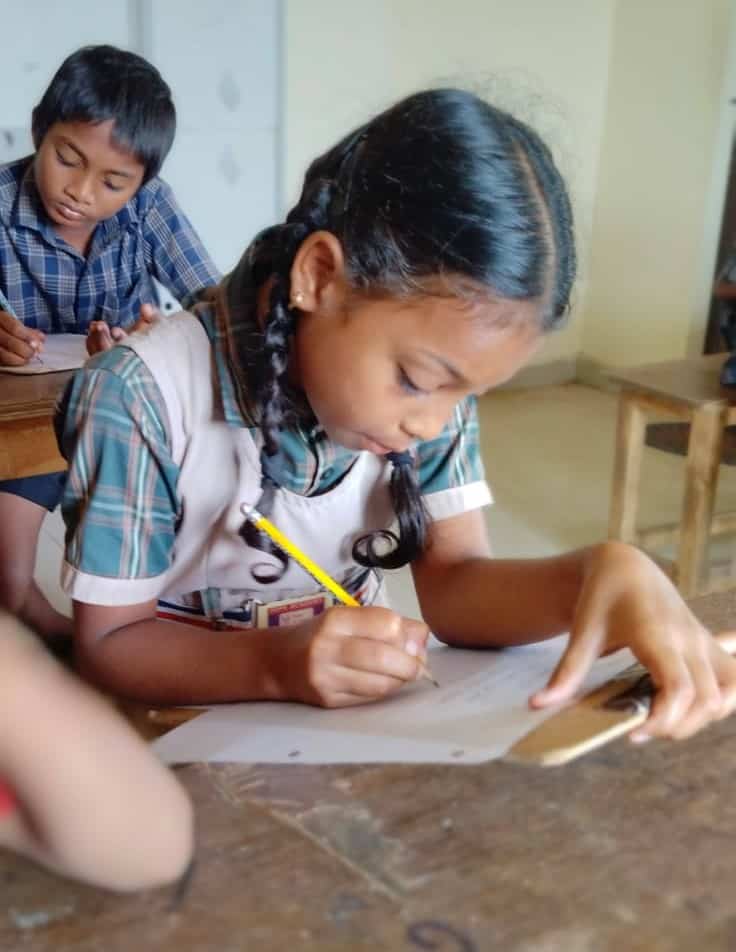 A young girl studies in a classroom at Children of Faith in India