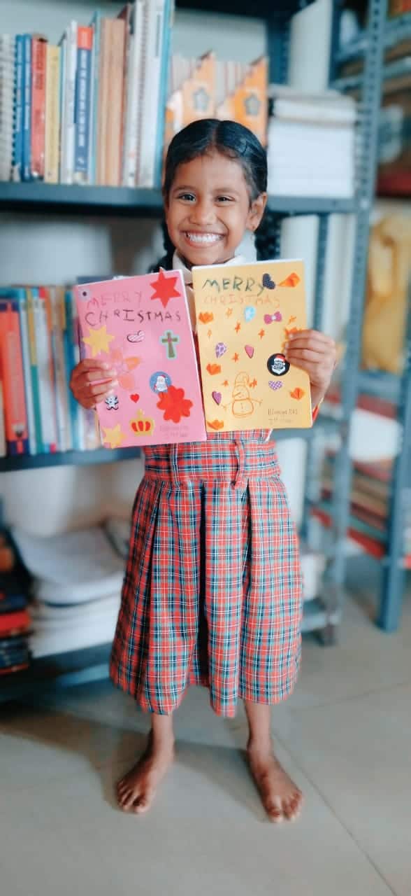 A young girl in India shows the beautiful cards she made as a thank you to her sponsor in the  Children of Faith Home in India.