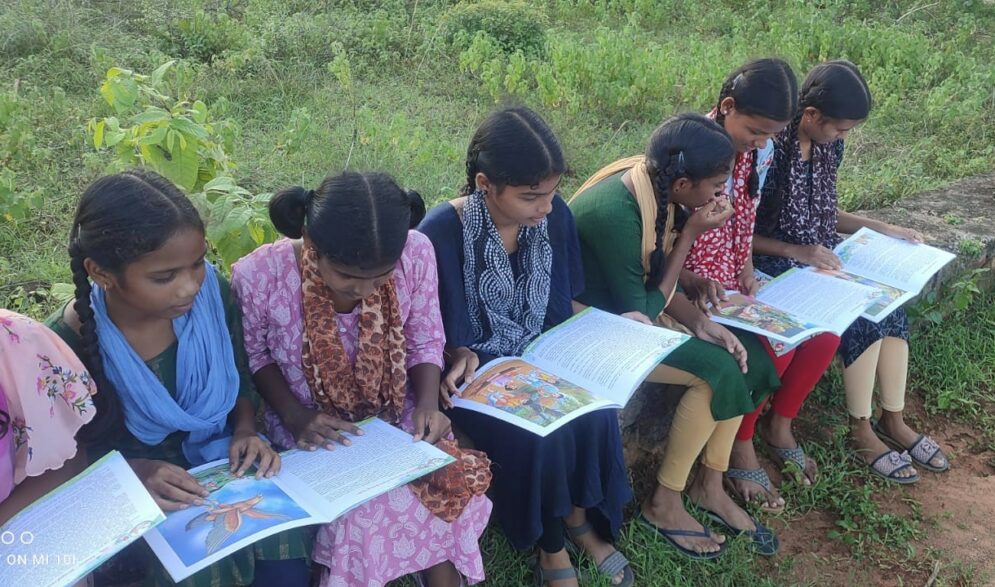 Girls enjoy reading donated books at the Children of Faith Home in India