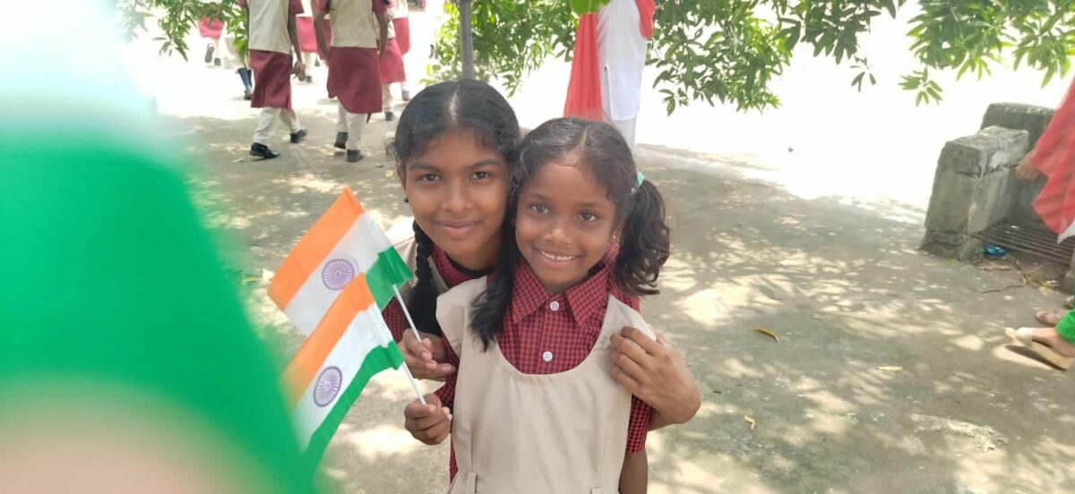 Girls wave India's flag as they celebrate India's Independence Day at the Children of Faith Home in Visakhapatnam, India