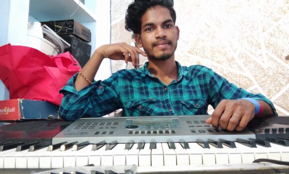 YOung man plays a keyboard at the Children of Faith Home in India