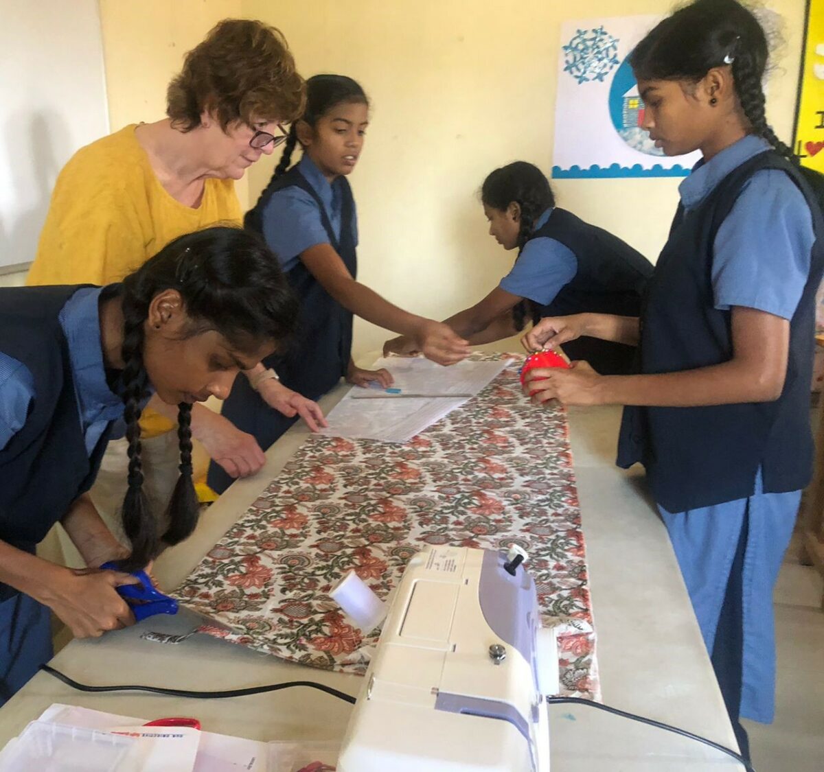 A visitor teaches sewing to girls in the Children of Faith Home in India