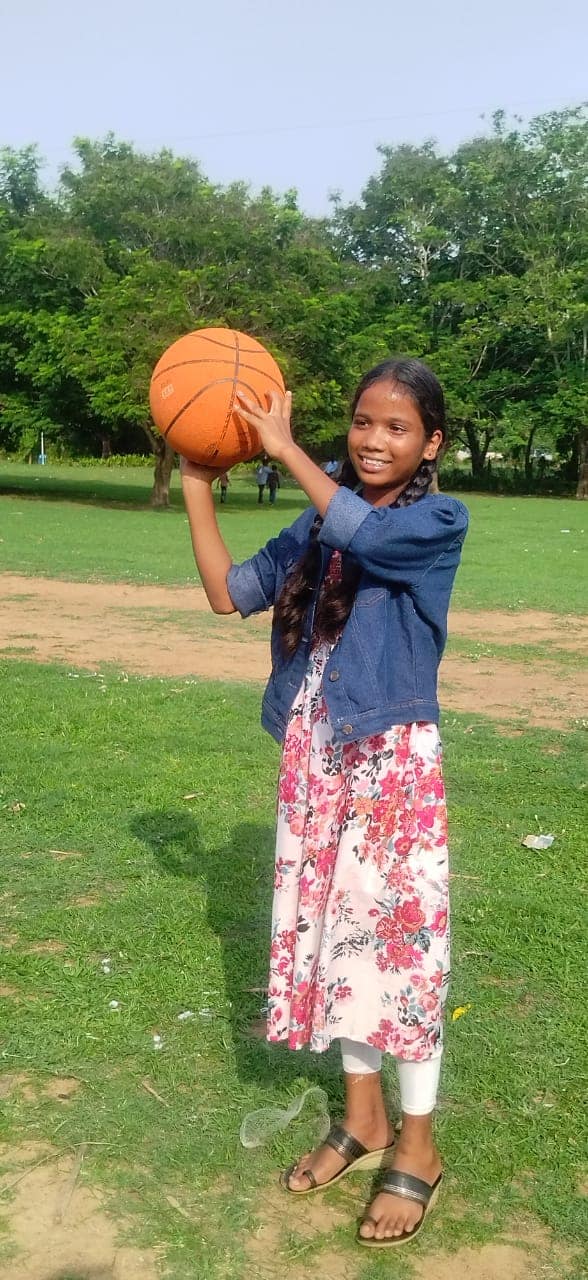 A girl from Children of Faith in India throws a ball while enjoying a day in the park