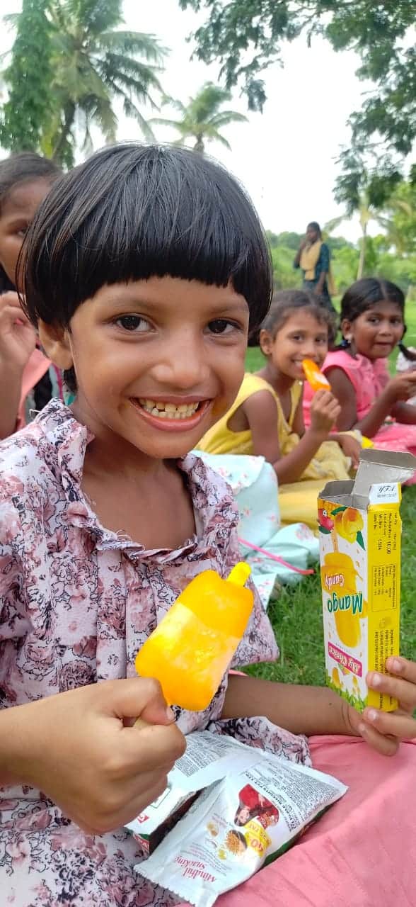 Girl from Children of Faith in India enjoys a popsicle at the park