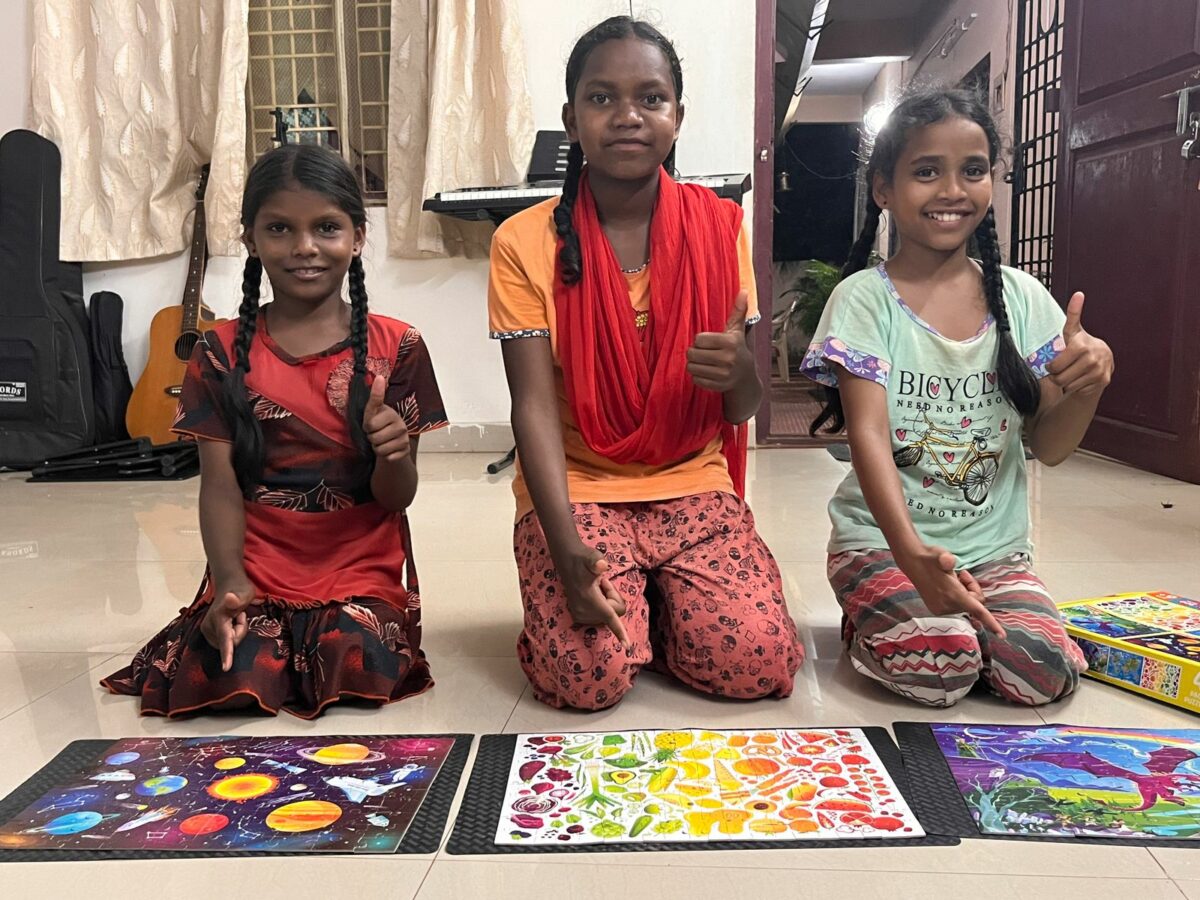 girls with completed jigsaw puzzles at Children of Faith in India