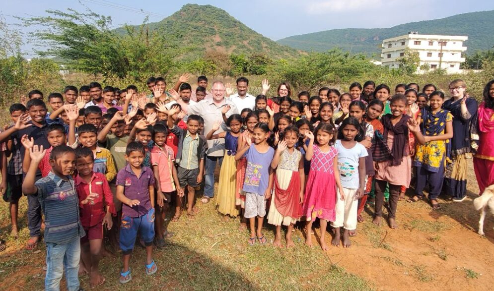 Visitors wave with children at Children of Faith Home in India