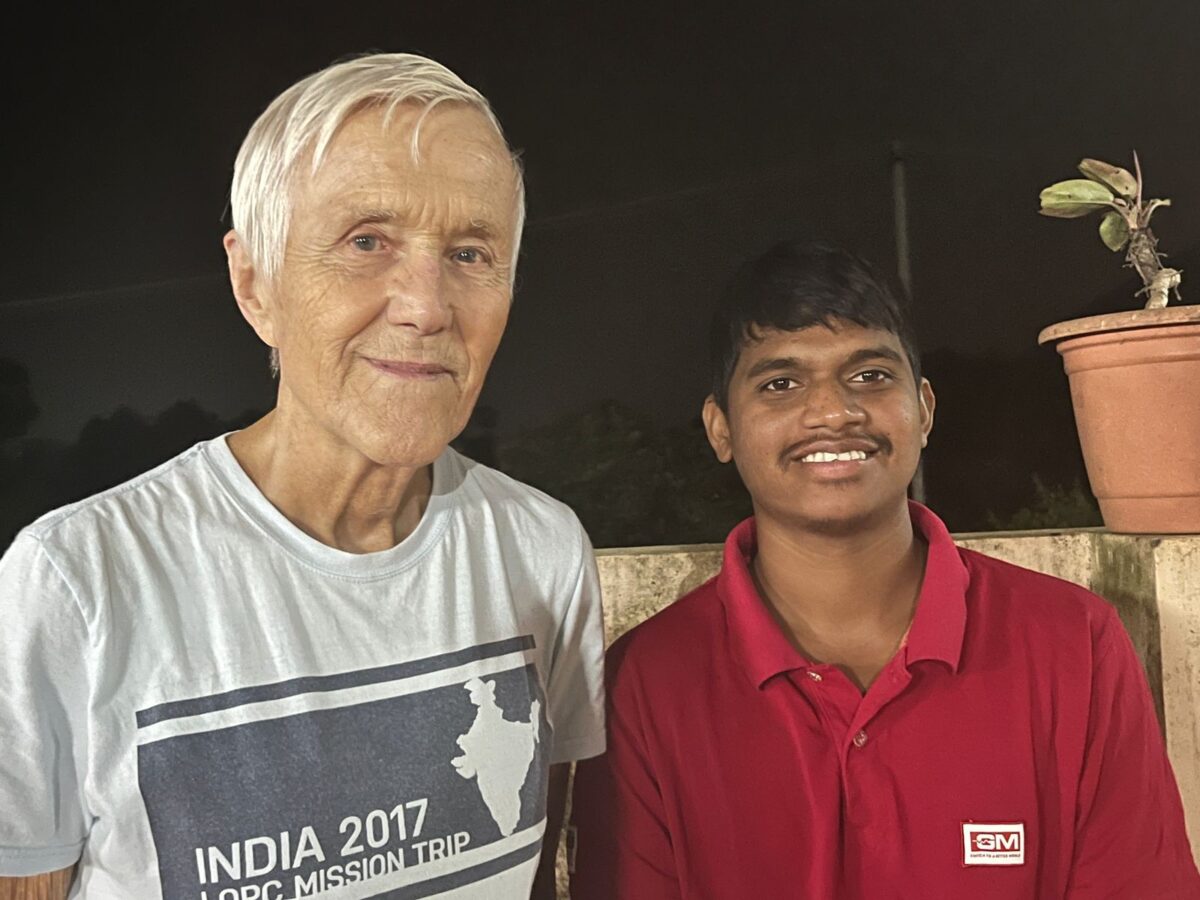 Tom, a visitors poses with a young man at Children of Faith in India