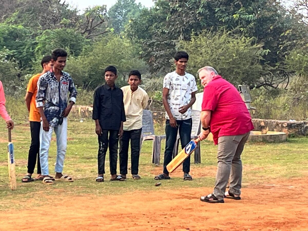 Visitors to children of Faith play cricket with the children.