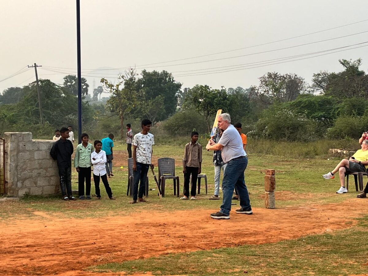 Visitors to children of Faith play cricket with the children.