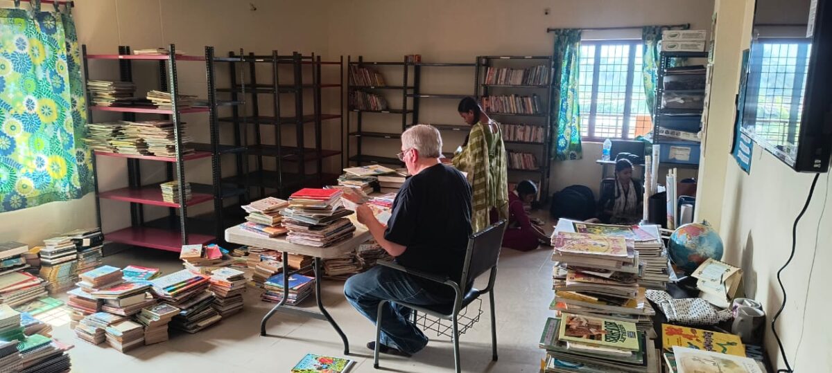 Volunteers clean and organize the library at Children of Faith in India