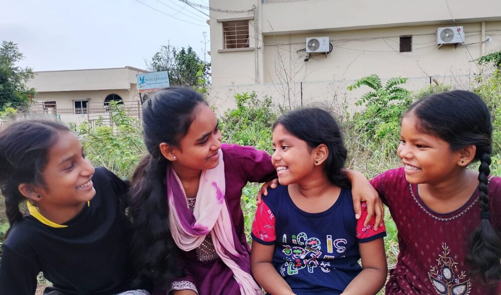 girls welcome a young child to the Children of Faith Home in Visakhapatnam India