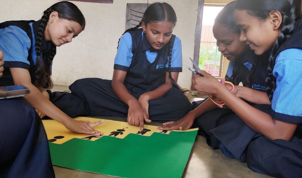 children making posters to decorate their classrooms at the Children of Faith Home in India